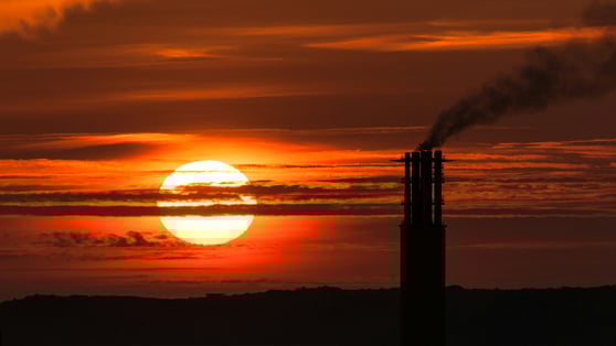 Image of sunset with chimney emitting smoke
