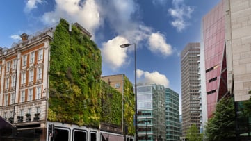 Building with plant exterior in a busy city