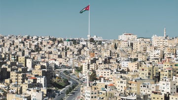Concrete buildings in Amman with Jordan flag
