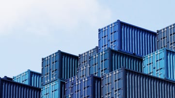 Stack of blue container boxes with sky background. Cargo freight shipping for import and export logistics. Business and transportation