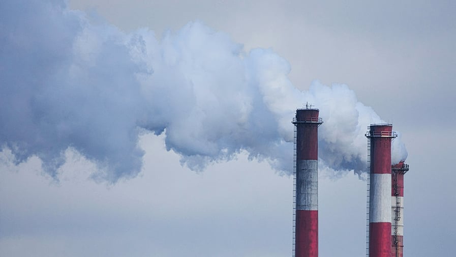 Industrial chimney releasing steam in the sky